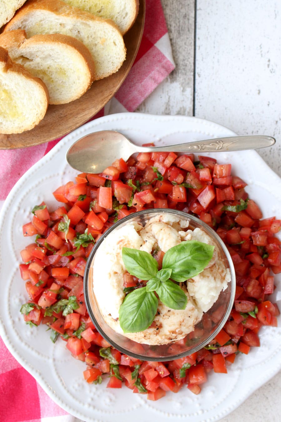 a platter of bruschetta with mozzarella cheese and toast on the side