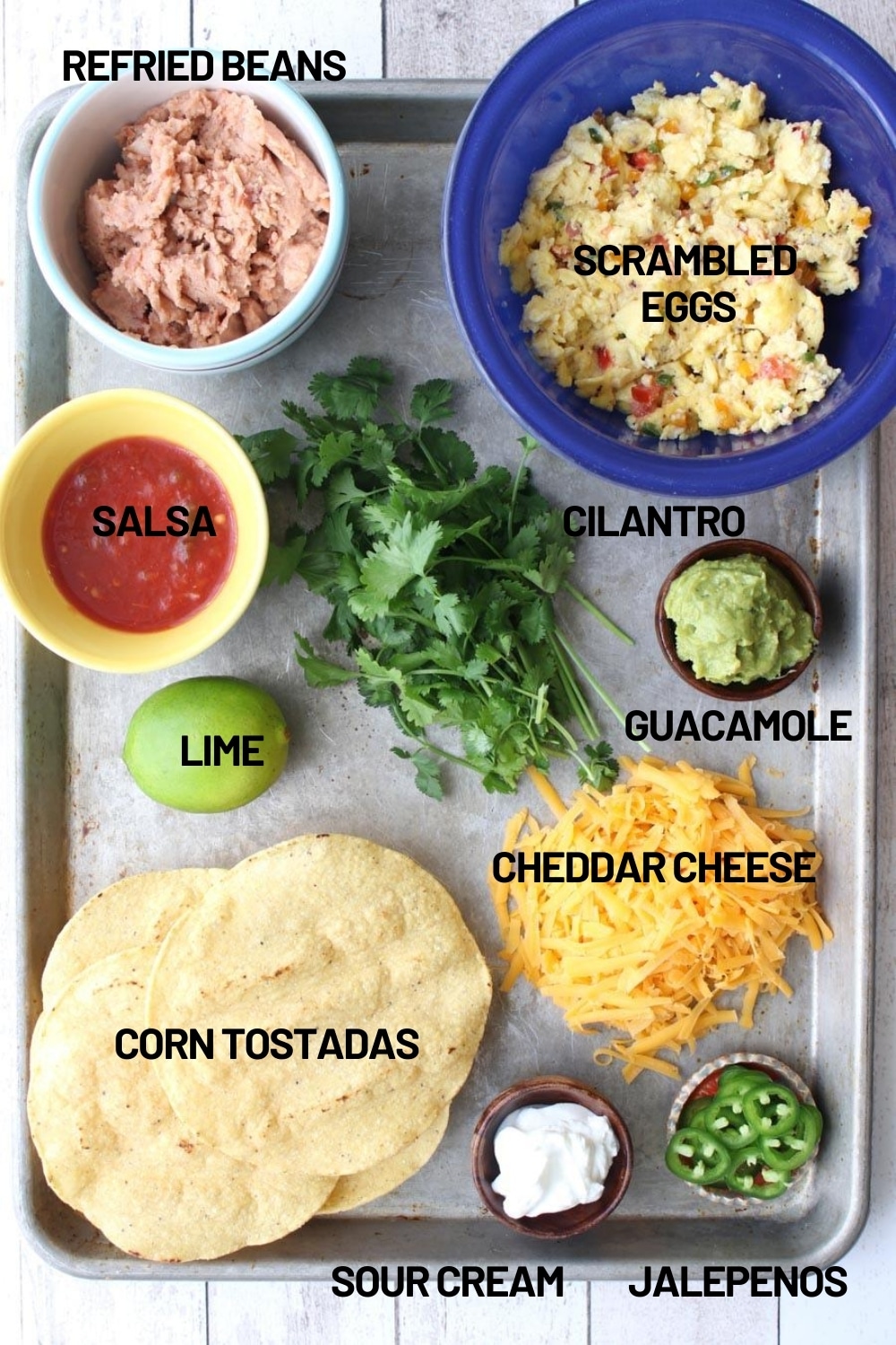 All of the ingredients needed to make huevous rancheros on a cookie sheet 