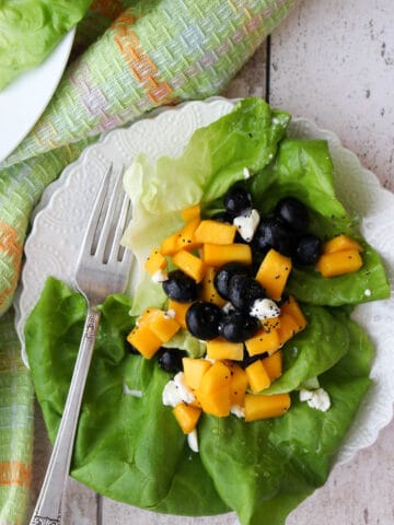 white plate with salad on it with a salad fork