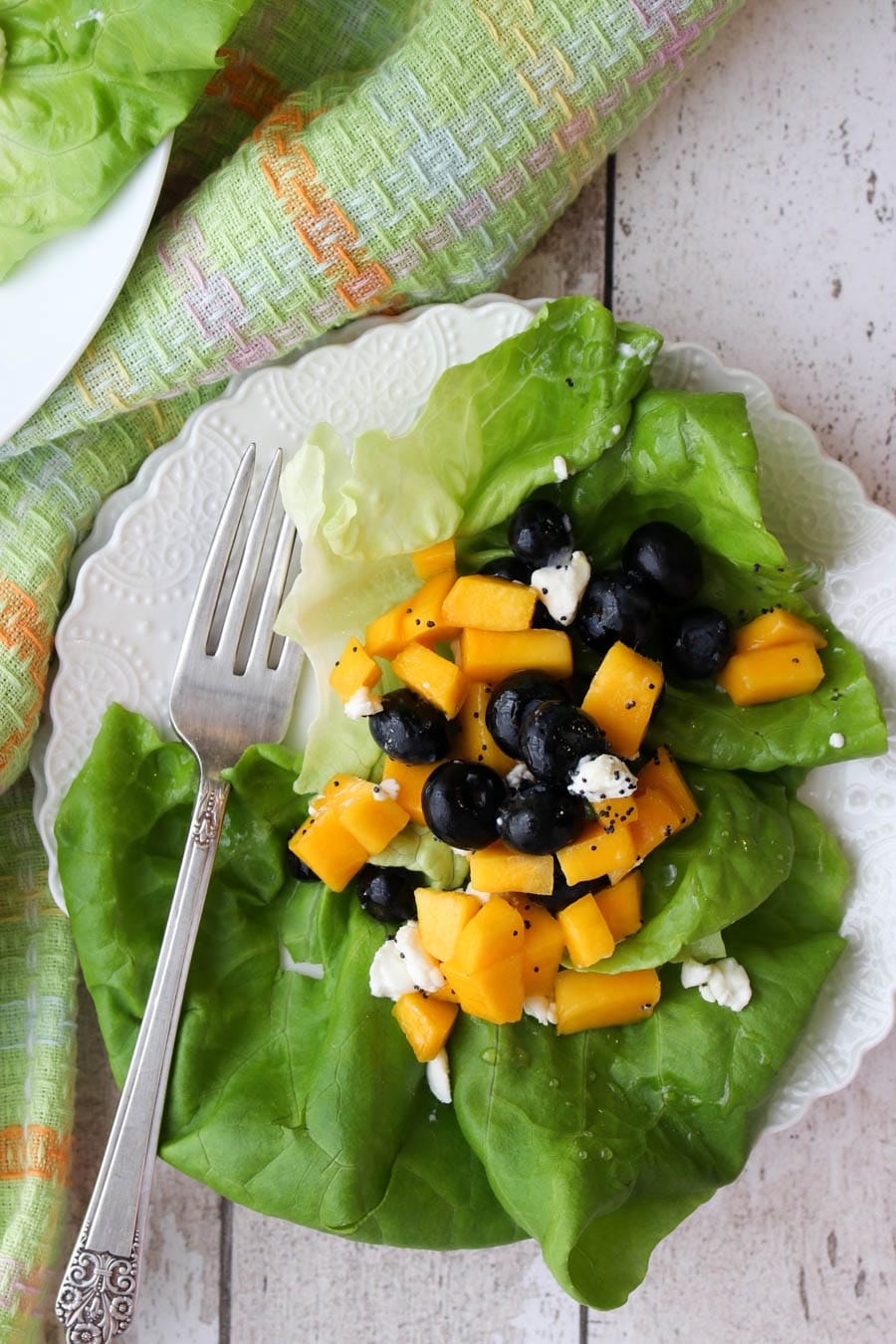 white plate with salad on it with a salad fork