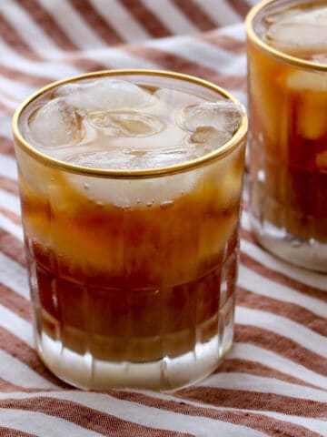 Glass of iced Irish Coffee with a striped background