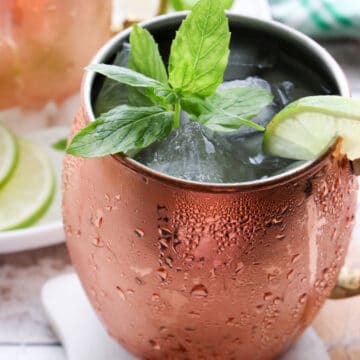 close up of a copper mug filled with ice, a drink and garnished with fresh mint