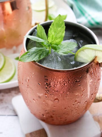 close up of a copper mug filled with ice, a drink and garnished with fresh mint