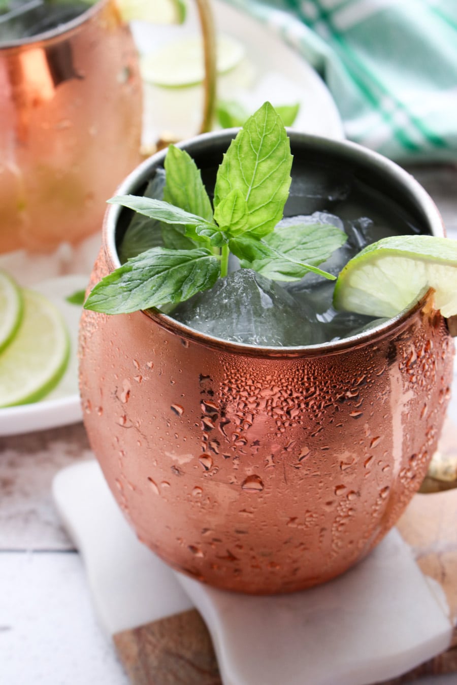 close up of a copper mug filled with ice, a drink and garnished with fresh mint