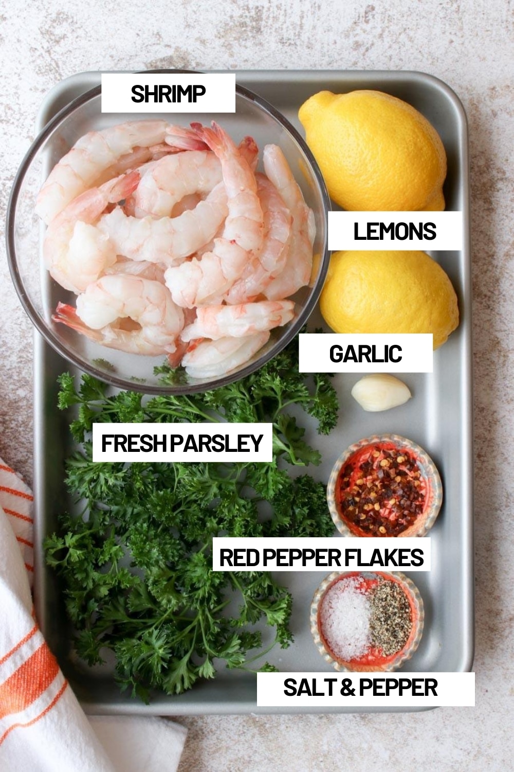 Cookie sheet with all of the ingredients needed to make grilled shrimp skewers