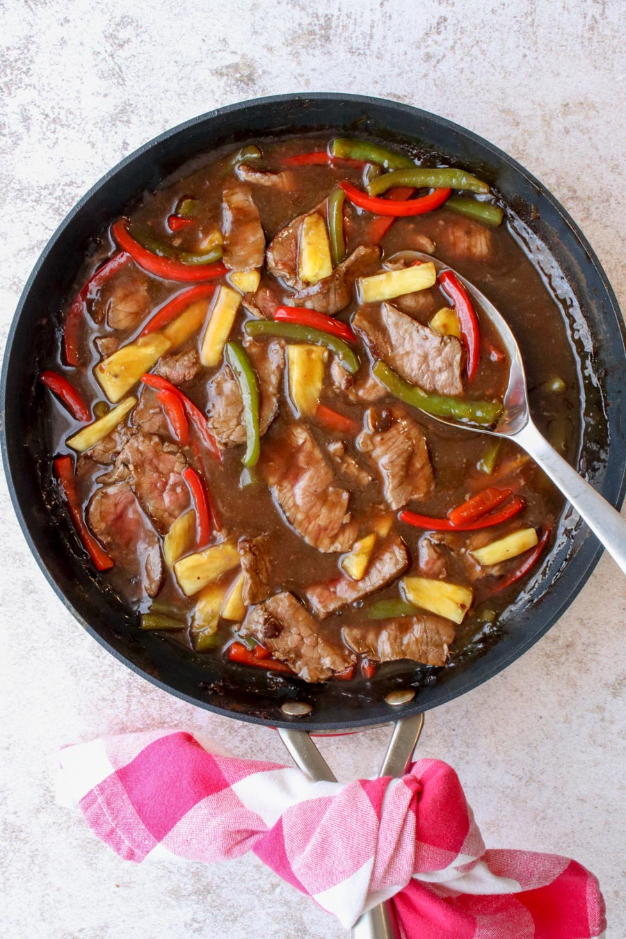 A skillet with cooked pepper steak 