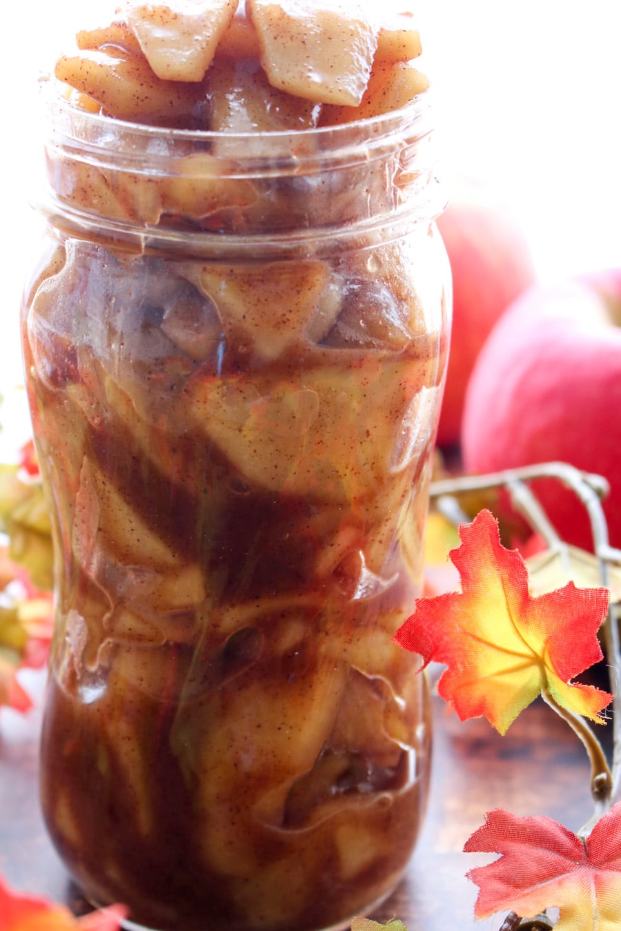 jar of apple pie filling with fall decor in background