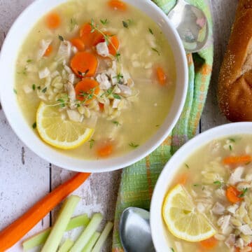 overhead shot of two bowls of soup with veggies on the side