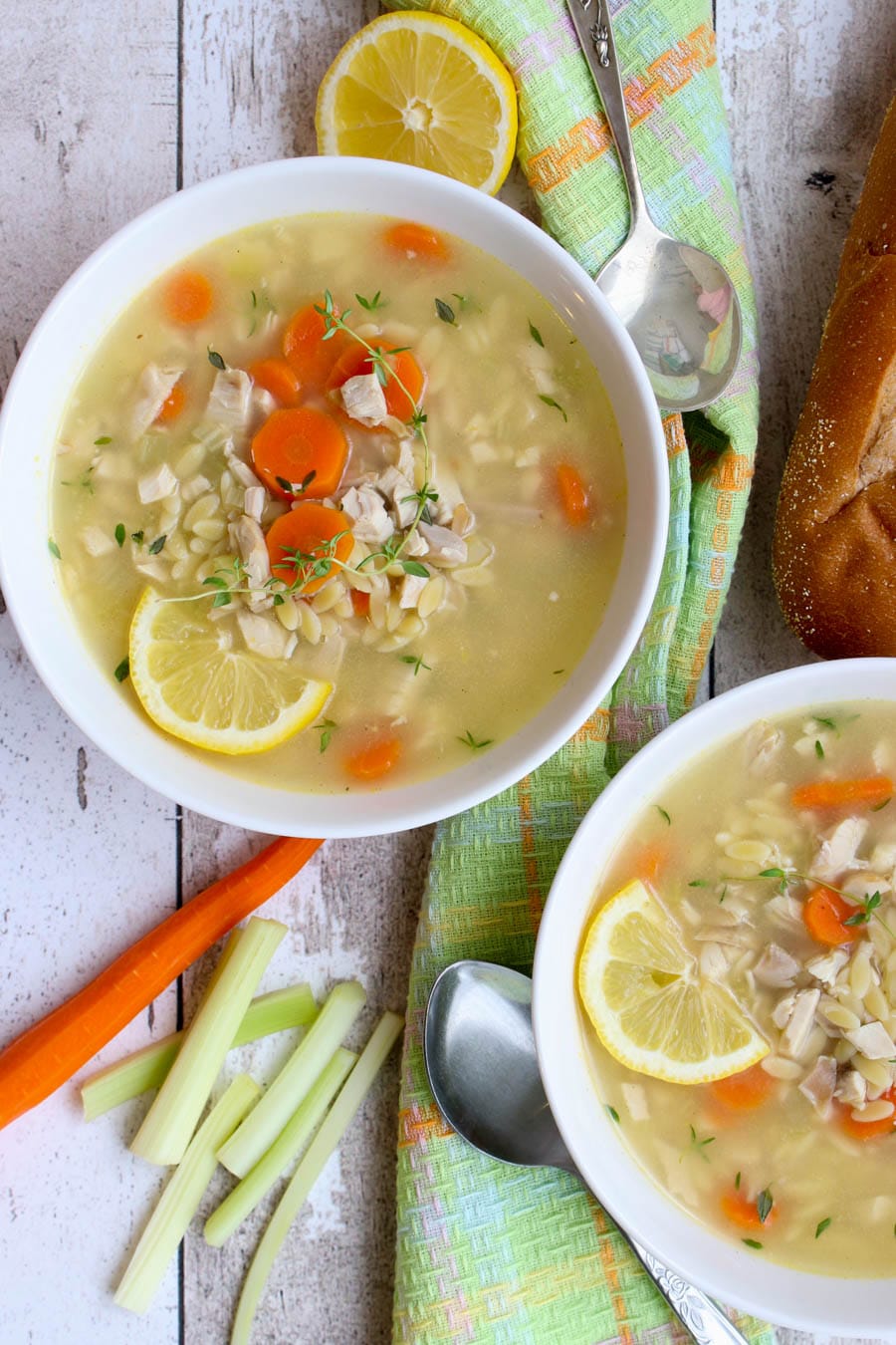 overhead shot of two bowls of soup with veggies on the side