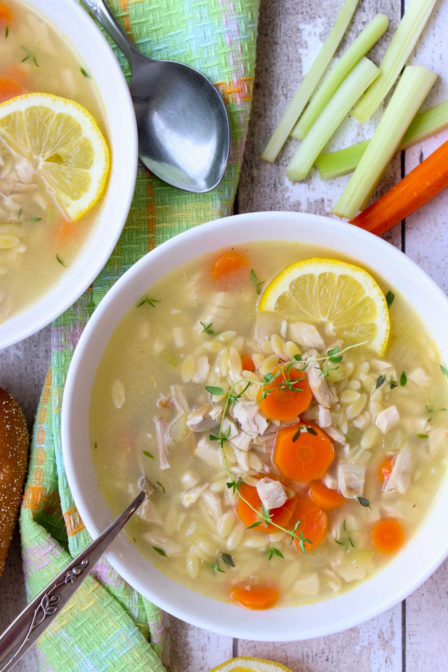 White bowl wit greek chicken soup and a spoon in it