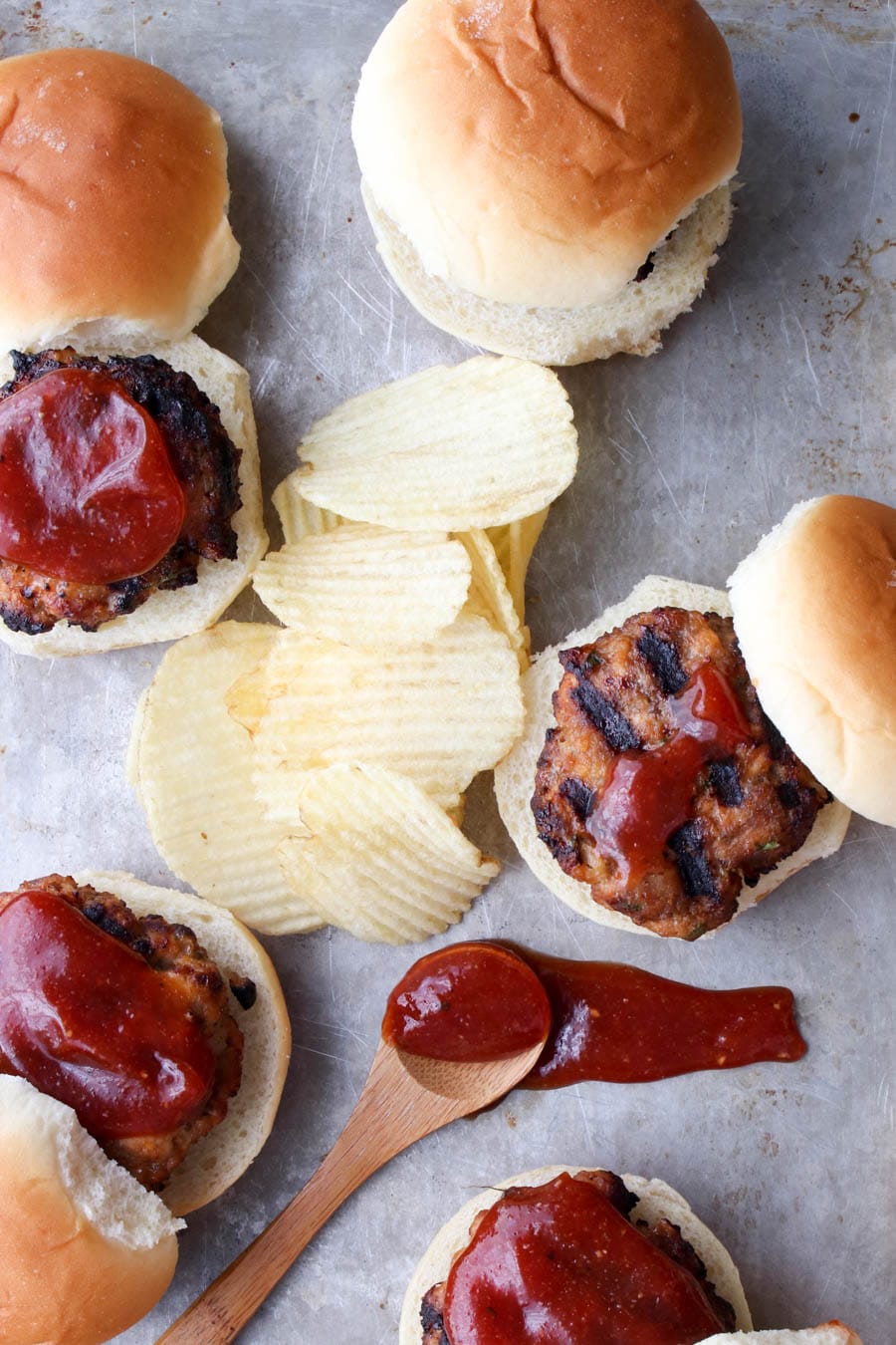 cookie sheet with meatloaf sliders and potato chips