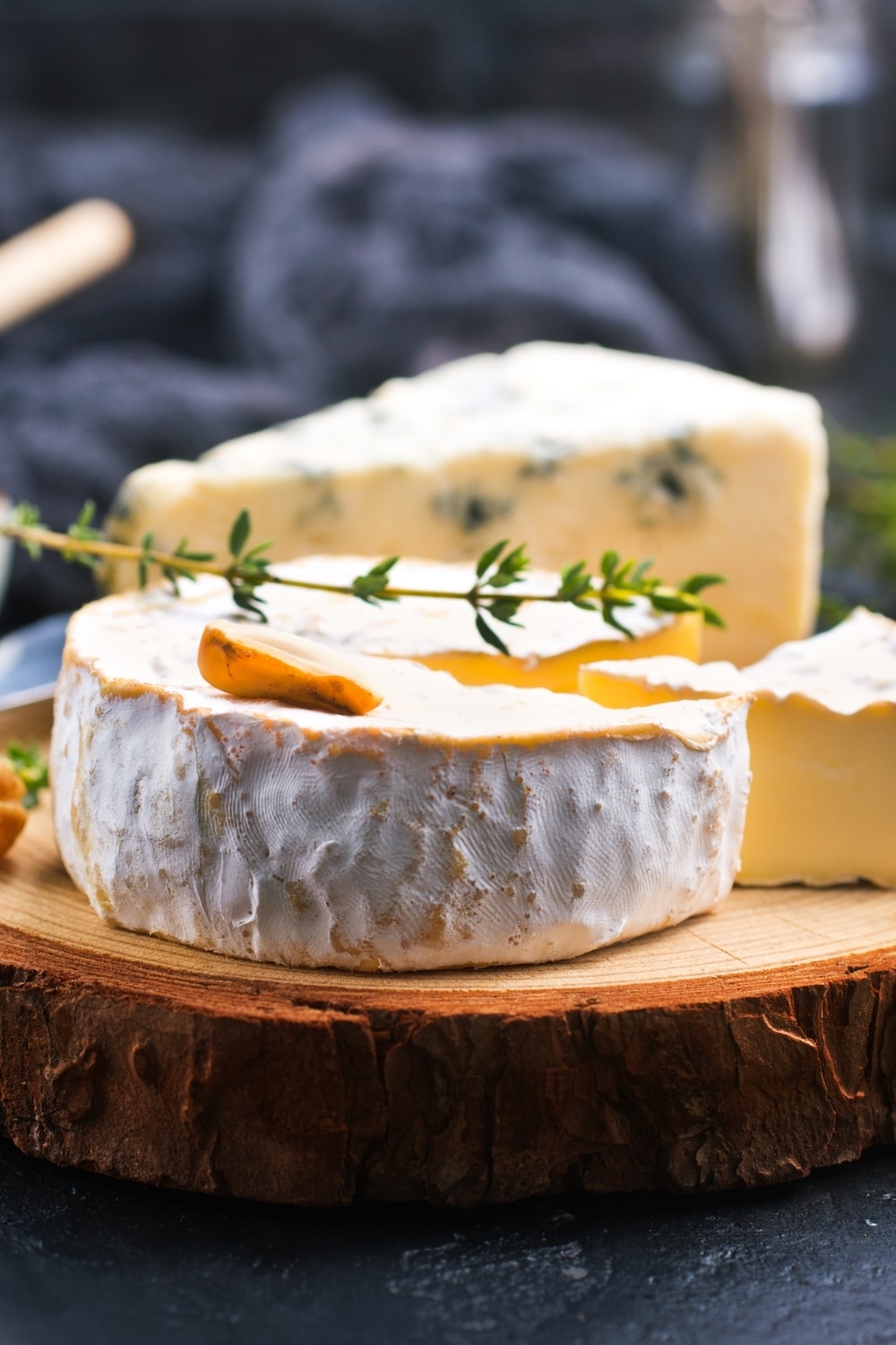 Brie Cheese wheel on a board with sprig of thyme on top