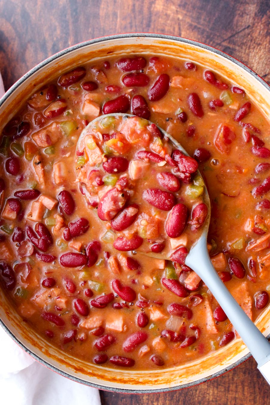 Red beans and rice being scooped out of a large pot