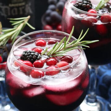 glass of red wine with a rosemary sprig.