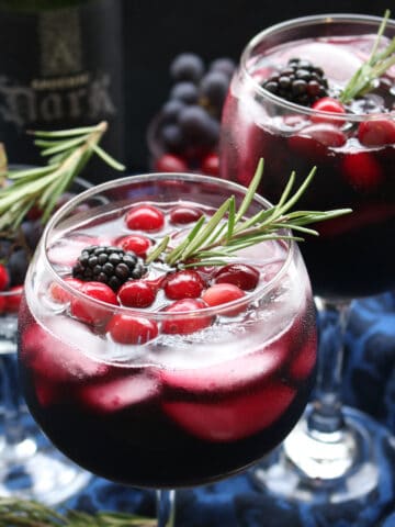 glass of red wine with a rosemary sprig.