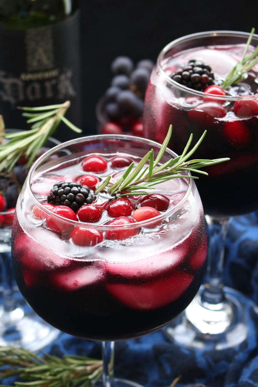 glass of red wine with a rosemary sprig.