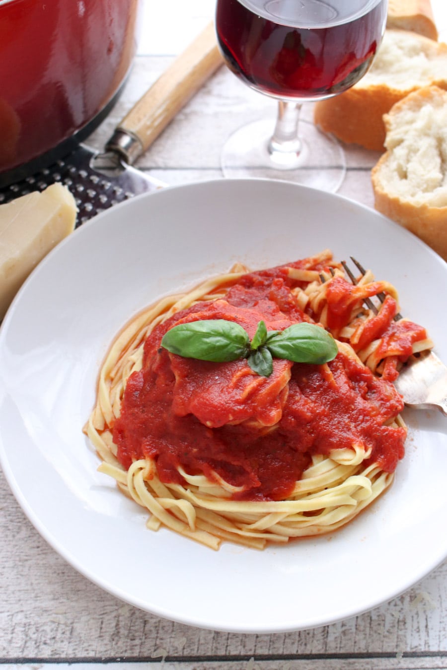 Spaghetti topped with red sauce and fresh basil 