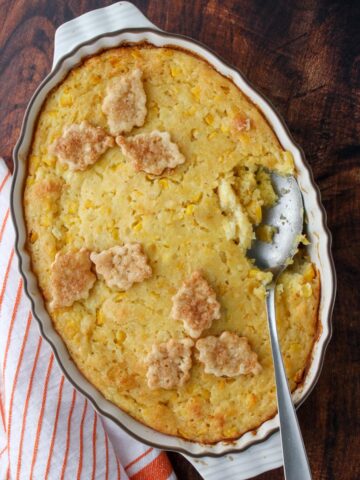 Cornbread pudding casserole with a spoon