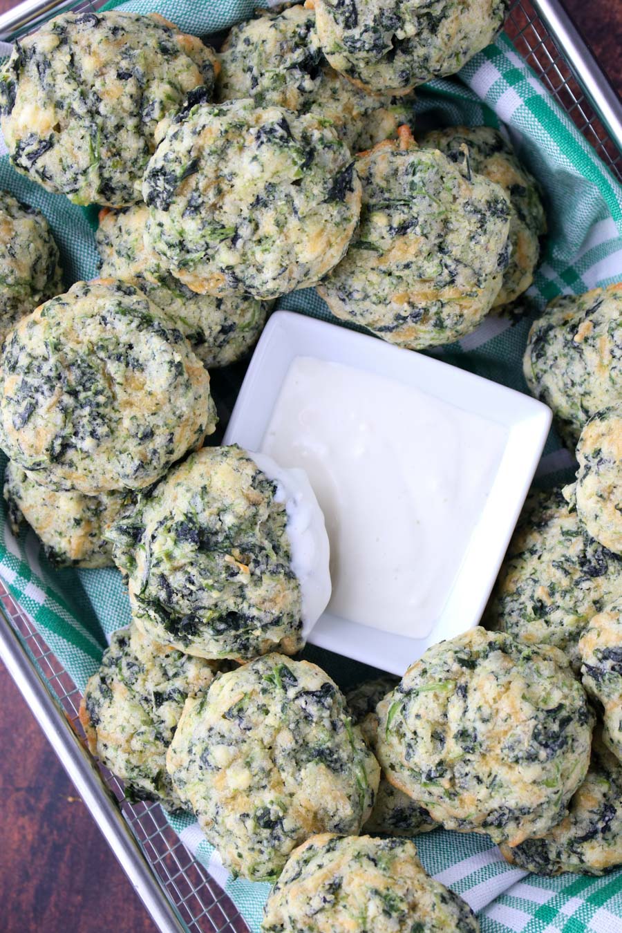 wire basket filed with spinach bits with a dish of blue cheese dressing 