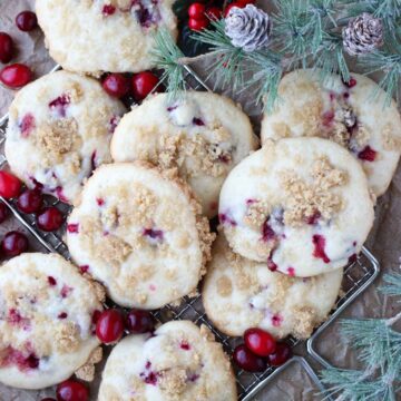 muffin top cookies on a wire rack with fresh cranberries and greens around them