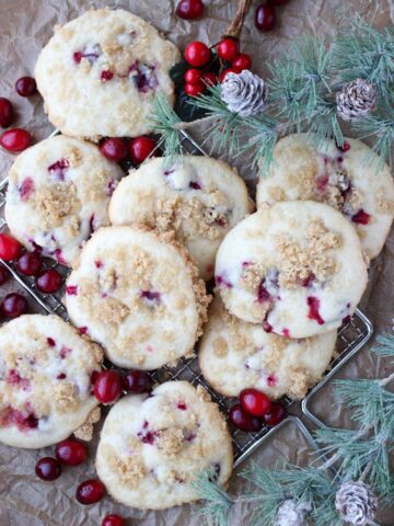 muffin top cookies on a wire rack with fresh cranberries and greens around them