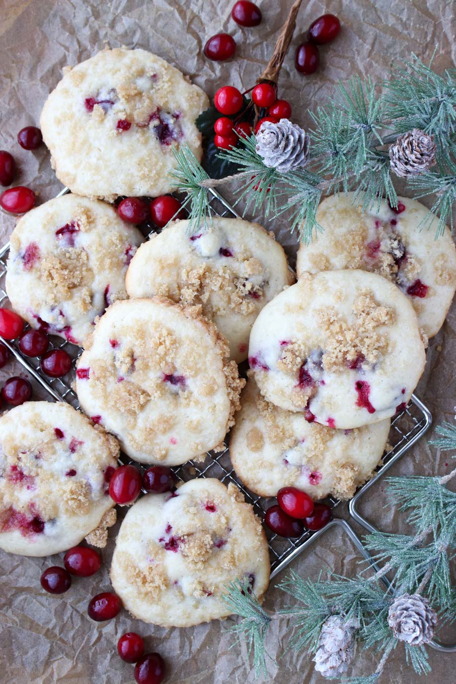 muffin top cookies on a wire rack with fresh cranberries and greens around them