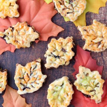 leaf shaped cookies spread out over fall colored leaves