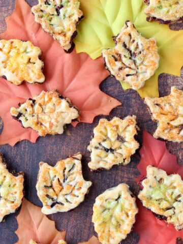 leaf shaped cookies spread out over fall colored leaves