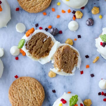 Cookie cut in half with sprinkles spread out on a marble background