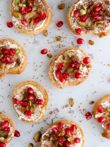 Pistachio pomegranate crostini on a marble slab