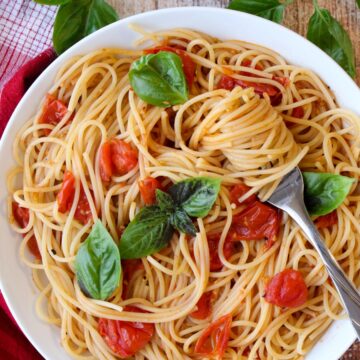 Bowl of pasta with tomatoes and pasta swirled around a fork