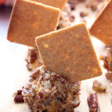 Pimento Cheese ball coated in nuts with a cracker stuck in it