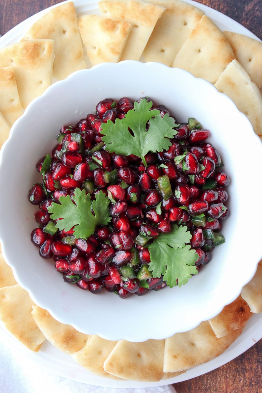 bowl of pomegranate salsa surrounded by crackers