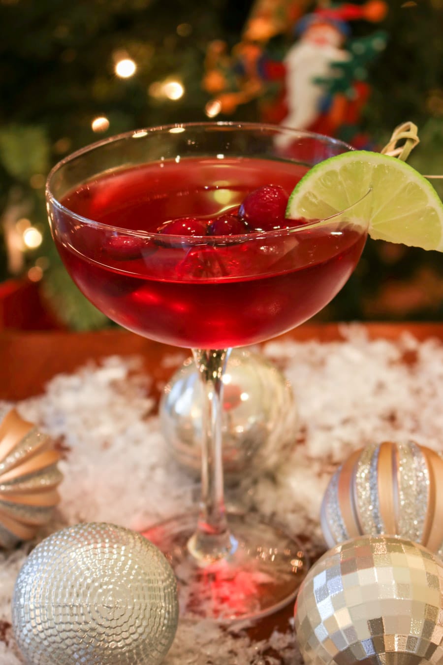 Scarlet colored cocktail in from of a Christmas tree