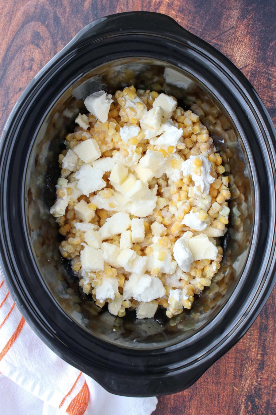 Black crockpot bowl with creamed corn ingredients