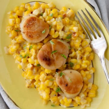 platter of creamed corn topped with three scallops