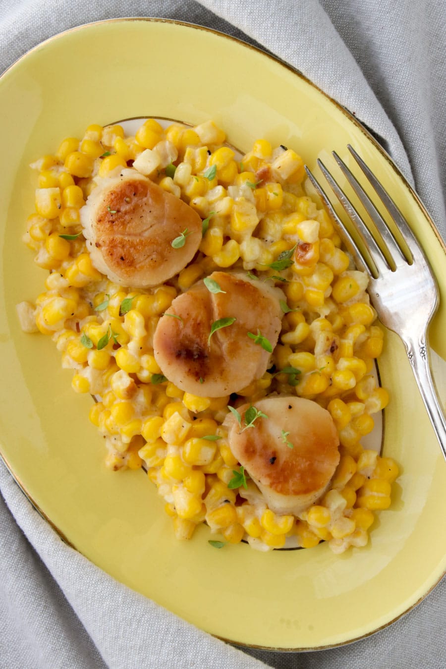 platter of creamed corn topped with three scallops