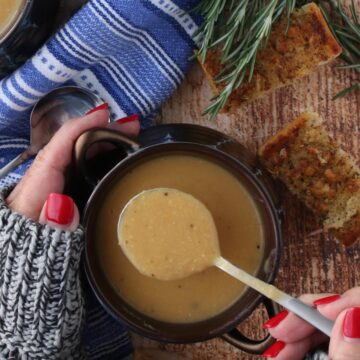 Woman's hands holding a bowl of bean soup