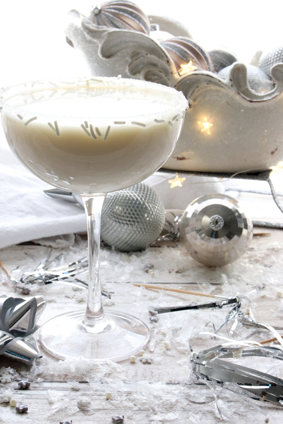 White Chocolate Martini with a sleigh filled with silver Christmas balls in the background 