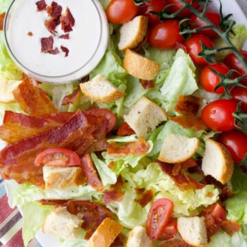 Platter of lettuce, tomatoes, bacon, croutons, and dressing