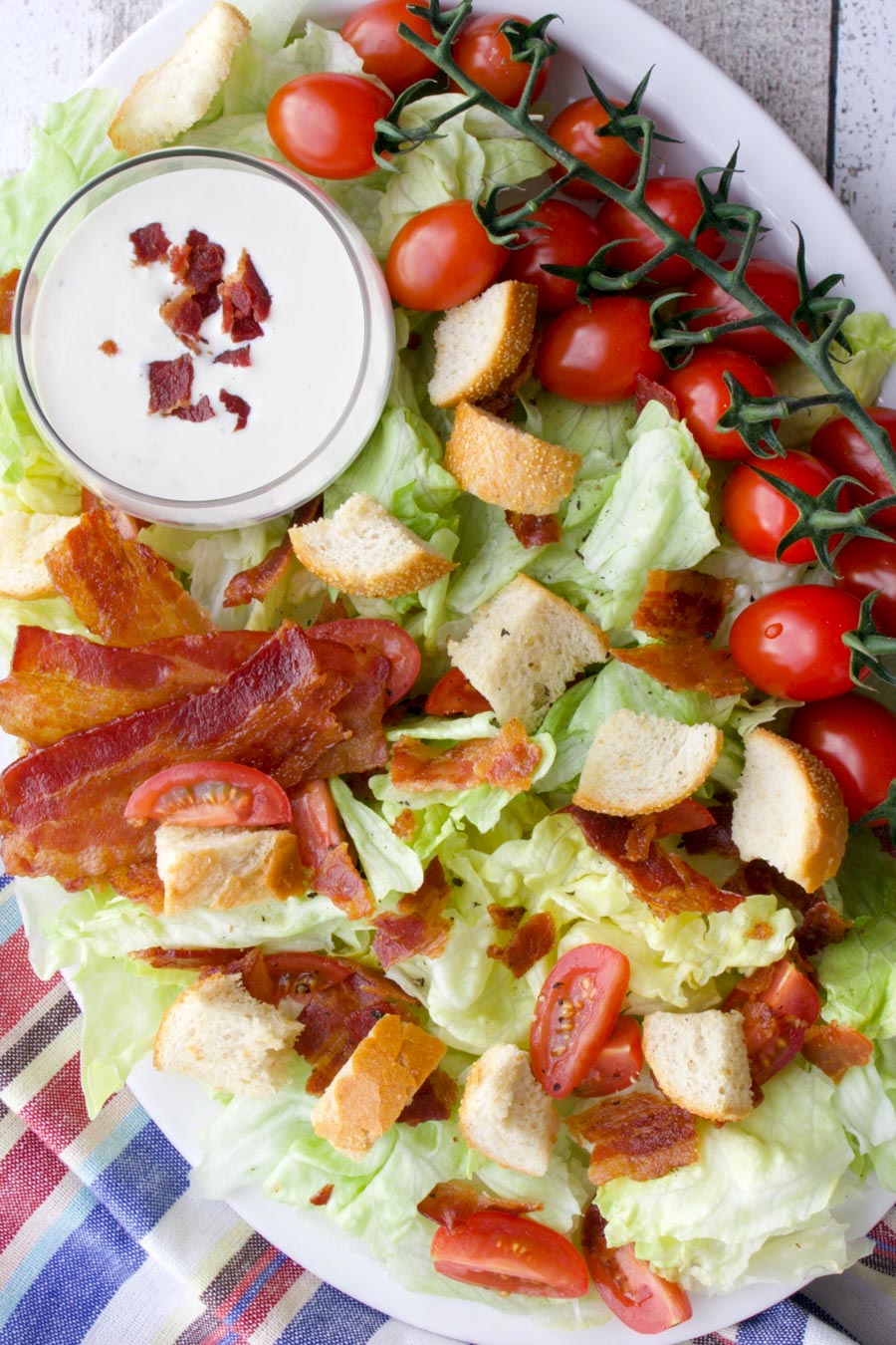 Platter of lettuce, tomatoes, bacon, croutons, and dressing