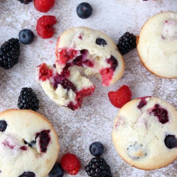 muffins on a counters surrounded by berries