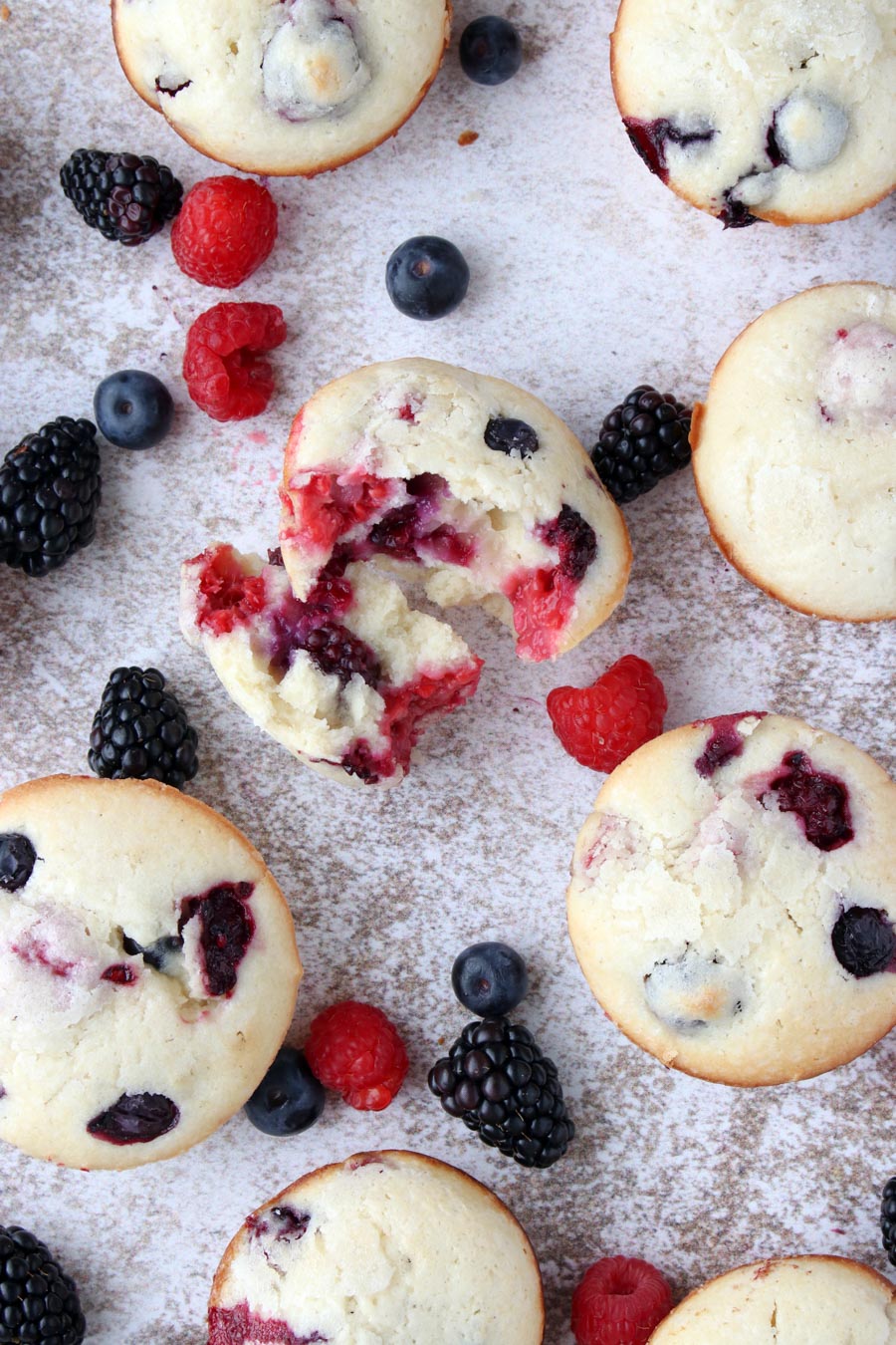 muffins on a counters surrounded by berries