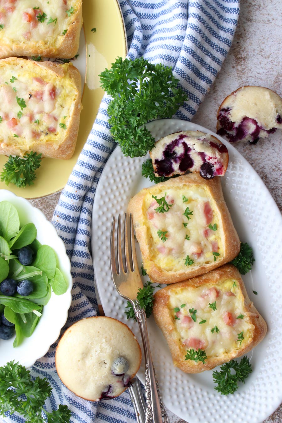 quiche boats on a plate with a muffin and salad on the side