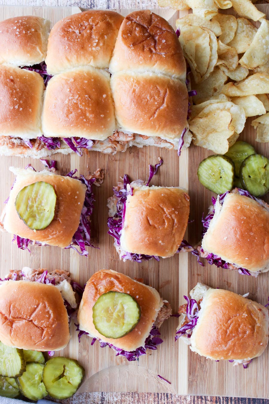 BBQ Sliders on a serving board with pickles and chips