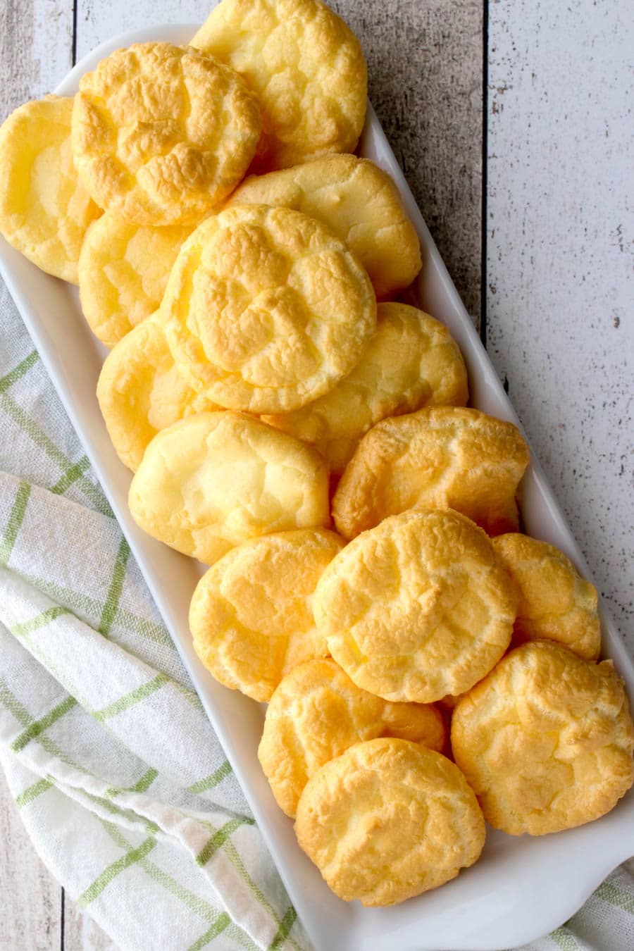 A long platter of cloud breads sitting of a green and white checked cloth