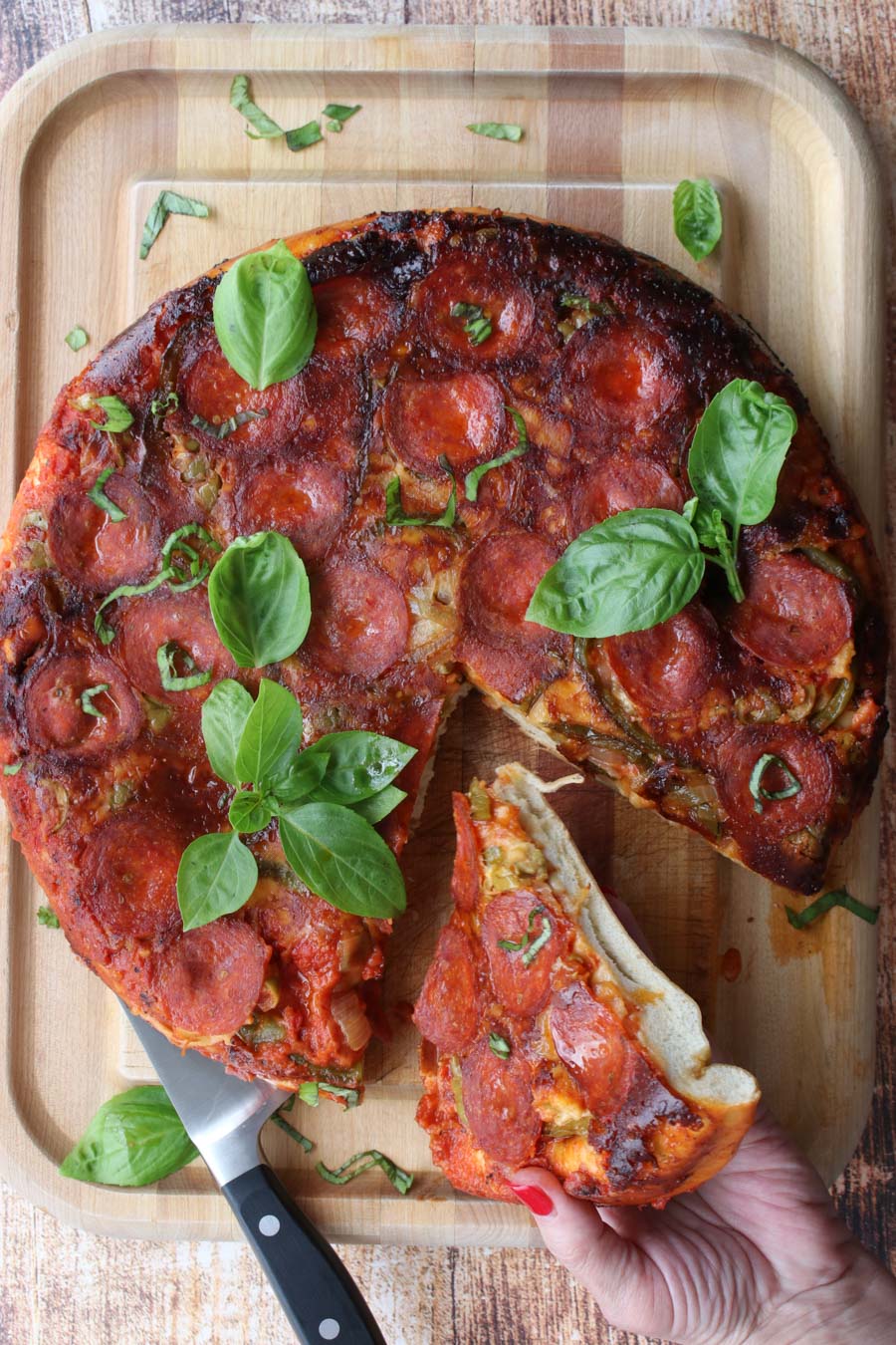 pizza with woman's hand holding a slice