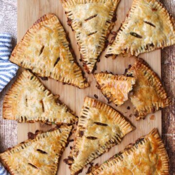 8 beef and potato hand pies on a cutting board