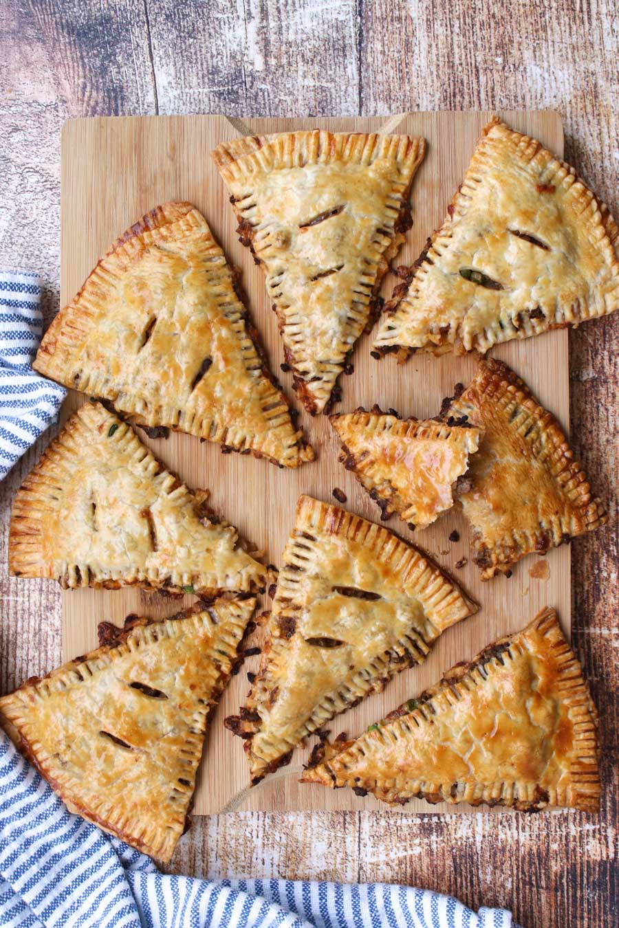 8 beef and potato hand pies on a cutting board