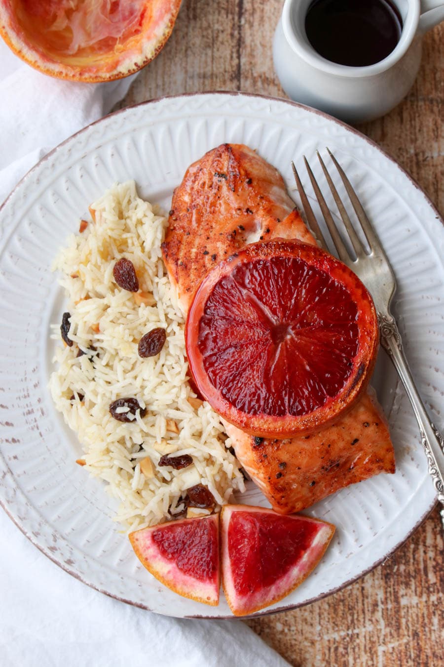 Salmon filet with sliced blood orange on top with a side of rice